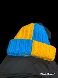 a blue and yellow knitted hat on a black background