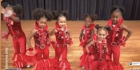 a group of children in red outfits posing for a photo