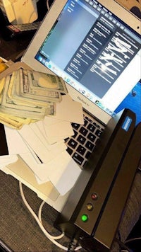 a laptop computer with a lot of money on it
