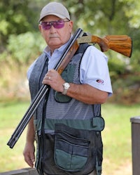 an older man holding a shotgun