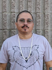 a man wearing a t - shirt with an owl on it