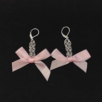 a pair of pink earrings with silver bows