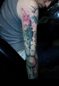 a man with a tree tattoo on his arm