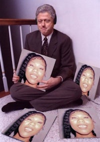 a man sitting on the floor with two pictures of a woman