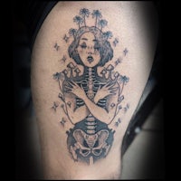 a tattoo of a woman with a skeleton on her thigh