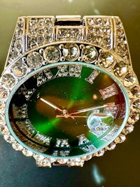 a green watch with diamonds on it