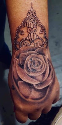 a hand with a rose tattoo on it