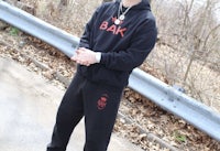 a man wearing a black hoodie and sweatpants