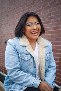 a smiling woman wearing a denim jacket