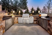 an outdoor kitchen with a grill and sink
