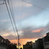 a sunset over a street with power lines and houses