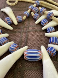 a necklace with blue and white beads and a pair of tusks