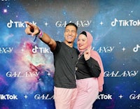 two people posing for a photo in front of a galaxy backdrop