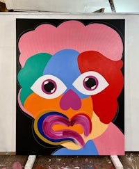 a painting of a colorful face in a studio