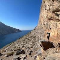 a hiker on a rocky path near a body of water