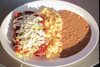 a plate of enchiladas with rice and beans