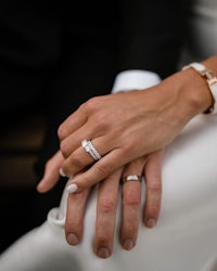 a bride and groom holding their wedding rings