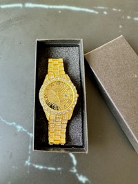 a gold watch with diamonds in a box