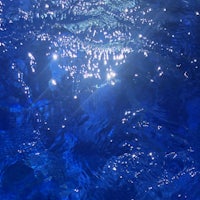 a close up of blue water with sunlight shining on it