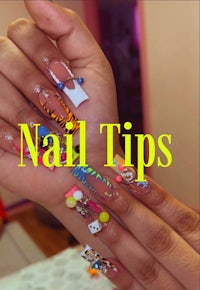 a woman holding up a hand with colorful nail tips