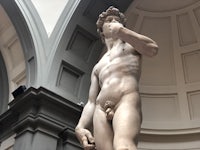 a statue of a naked man in a museum
