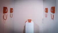 a group of orange telephones in a white room