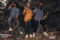three young men on bicycles in the woods