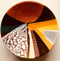 a plate with a brown, orange, and yellow design