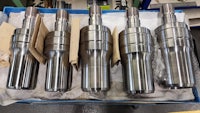 four stainless steel cylinders sitting in a box