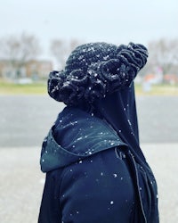 a woman wearing a black hat in the snow