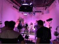 a group of people in a room with pink lighting