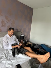 a man using a laptop on a bed