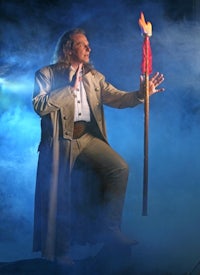 a man holding a torch in front of smoke