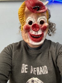 a woman wearing a clown mask