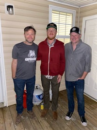 three men standing on a porch with hats on