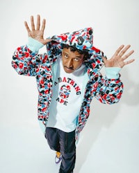 a man in a camouflage hoodie posing for a photo