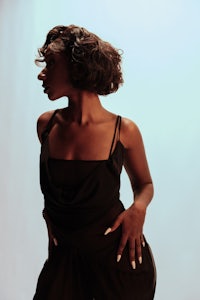 a black woman in a black dress posing for a photo