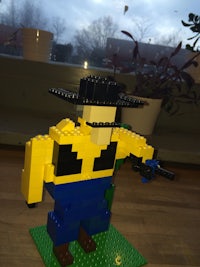 a lego figure holding a gun on a table