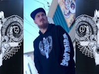 a man wearing a black hoodie with a skull on it