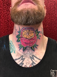 a man with a tattoo of a flower on his neck