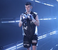 a young man wearing boxing gloves in a dark room