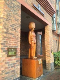 a statue of a soldier in front of a brick building