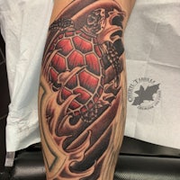 a tattoo of a turtle on a man's forearm