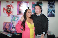 a man and woman posing for a photo at an art show