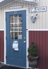the front door of a small building with a blue door
