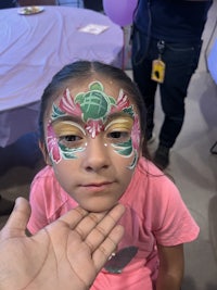 a little girl with face paint on her hand