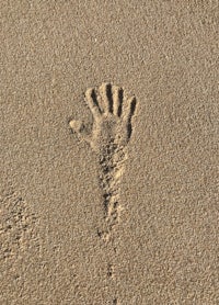 a hand print in the sand on a beach