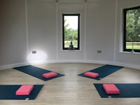 four yoga mats in a room with windows