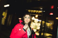 a woman in a red jacket walking down the street