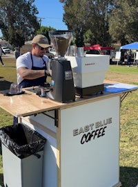 a man is making coffee at an outdoor event